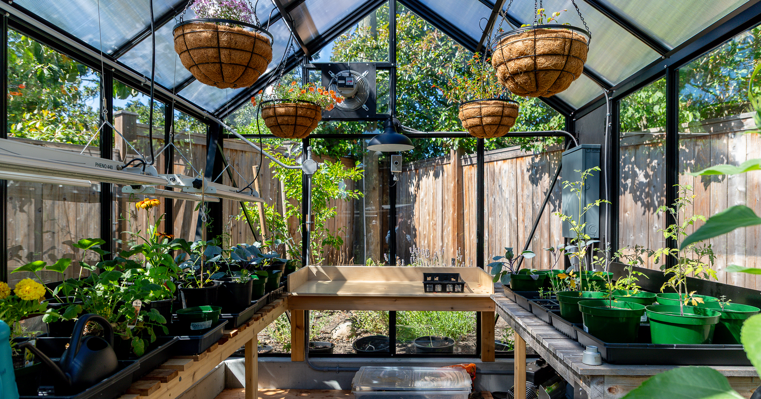 Cottage greenhouse by BC Greenhouse Builders inside with potting benches and seed trays