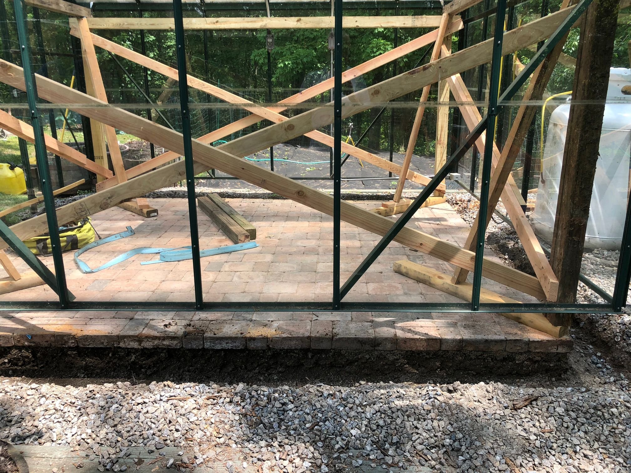 Greenhouse being secured to a brick foundation after a tornado with no damage to the greenhouse. Greenhouse made by BC Greenhouse Builders