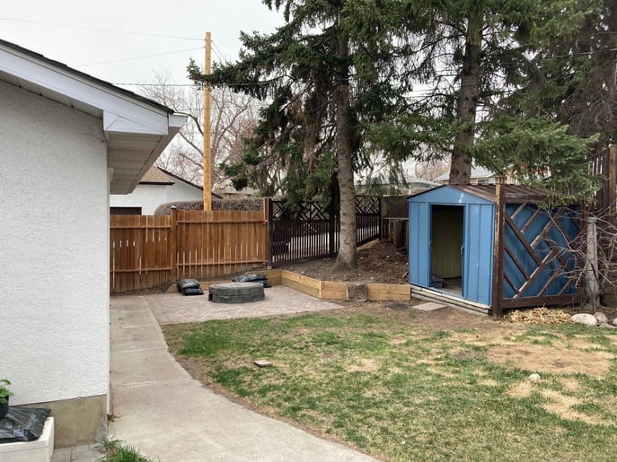 My new back yard where I am squeezing in my Cape Cod between the garage (left) and trees right as seen last May