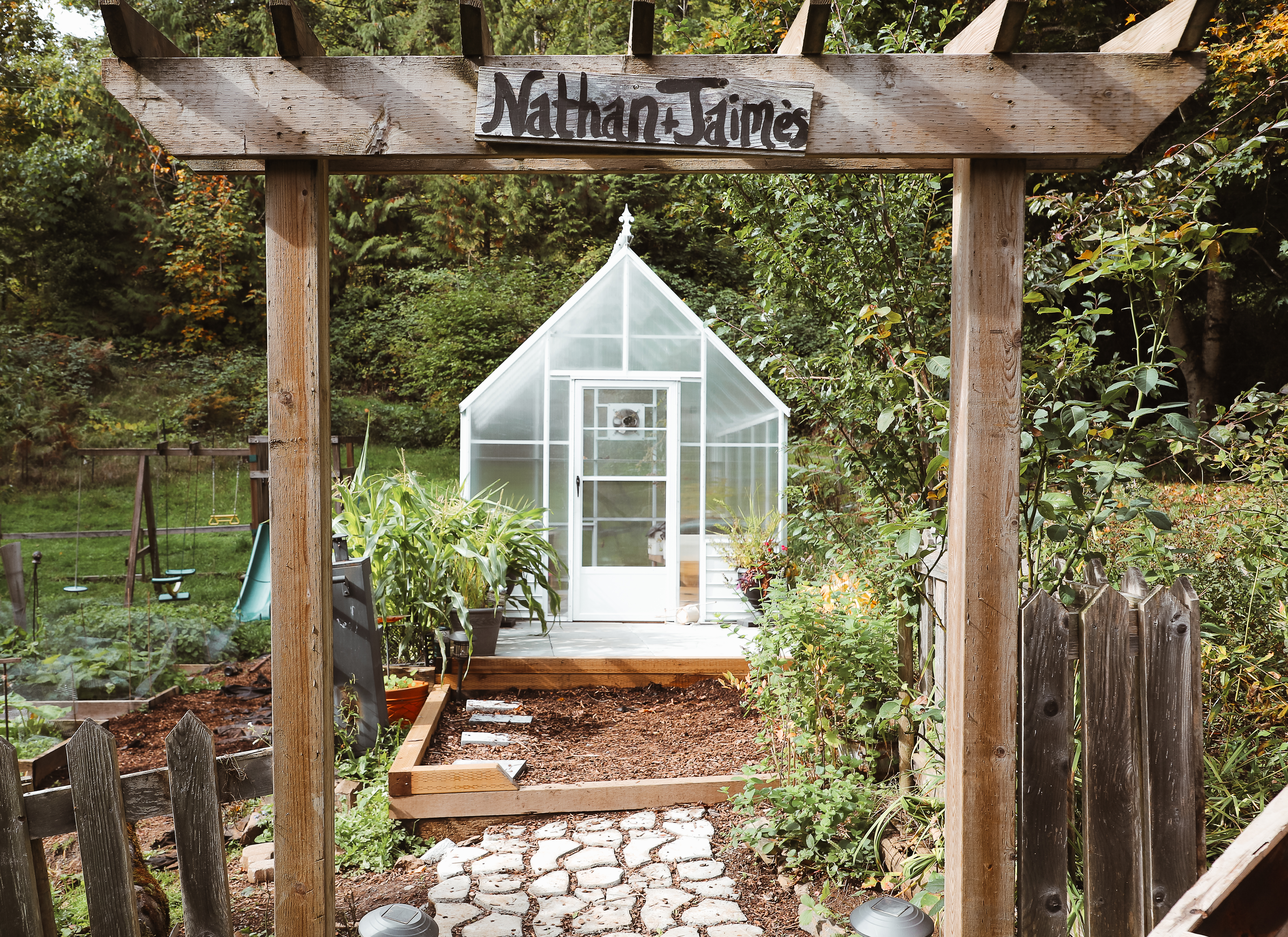 Greenhouse nested in a fenced in garden